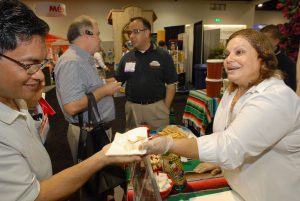 Marcela Jimenez, who works with Los Altos food products in Industry, California, serves samples of fresh Mexican cheese at the Expo Comida Latina trade show exhibit at the San Diego Convention Center. Founders of the company began by importing cheese from Mexico, but later began production in the United States.Photo - David Maung