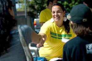 Patty Cueva atendiendo a clientes en una venta de patio llevada a cabo por Logan Heights Neighborhood Council.