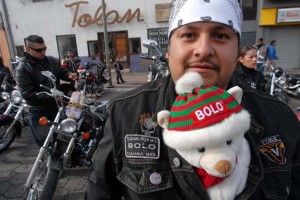 motorcycles 04 Marco "El Bolo" Escartin, 25, poses for a photograph with a teddy bear that he will give away during the Toy Run. Photo - David Maung