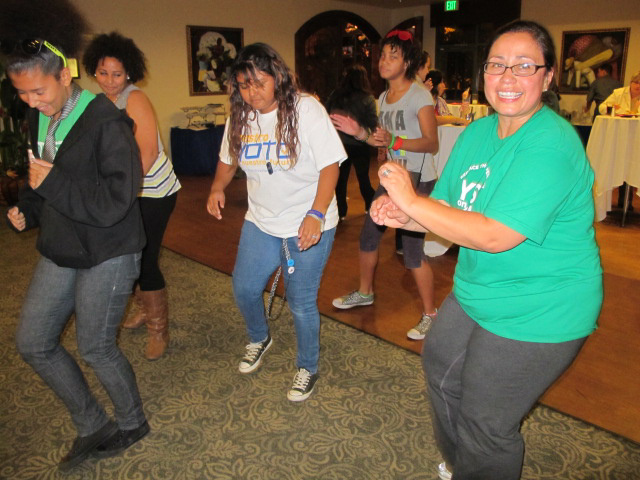 ACLU organizer Norma Chavez (right) dances La Macarena with Nuestro Voto volunteers in Escondido. The youths volunteered for Nuestro Voto, Nuestro Futuro. They canvassed neighborhoods, phone banked, leafleted supermarkets, registered voters and served as poll watchers at several polling stations. Photo by Mark Day