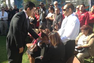 El miembro del concejo, David Alvarez entrega una placa a la madre de Jennifer Moreno.