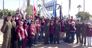 USO volunteers and members of the military gather together for a group photo.