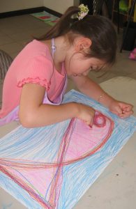Niña del Programa Valores Artísticos, pintando un lienzo
