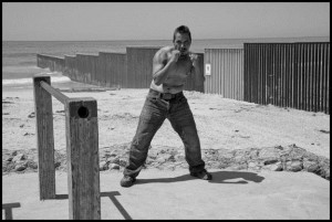 TIJUANA, BAJA CALIFORNIA NORTE, MEXICO - 9SEPTEMBER14 - Jorge, a boxer, practices in an outdoor exercise yard next to the border wall, on the Mexican side of the border wall between Mexico and the U.S. Copyright David Bacon