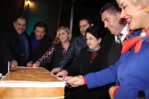Directivos e invitados partiendo el enorme pastel