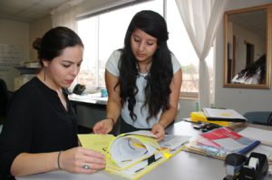 Eloisa Mata, left, and Maria Calixto, right, work on DACA cases