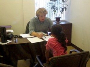 Lawyer Matt Cannon, Children’s Program Director for Casa Cornelia Law Center, speaks with a young girl.