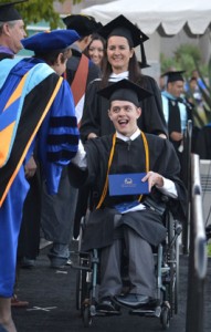 Brandon Kover was accompanied at Cuyamaca College’s commencement ceremony by his favorite instructor, Lindy Brazil, who helped her former student through the processional. Photo by Ion Moe/Grossmont-Cuyamaca Community College District.