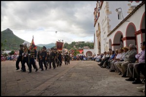 Children representing the soldiers of Cortes march in front of the community authorities.